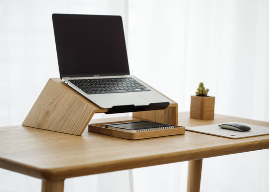 wooden laptop stand on a wooden desk