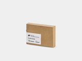 Kraft paper box with a label on a white background Box of to-do cards with a white card on top on a light gray background |-