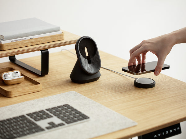 black magsafe iphone stand on a wooden standing desk | -