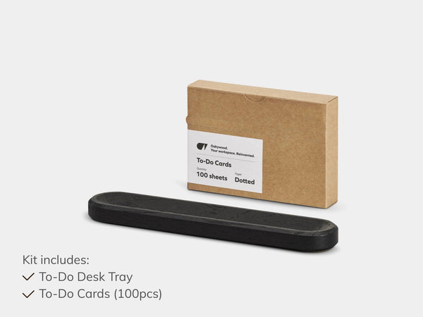 Black to-do desk tray and brown cardboard box with white label on a light gray background | black