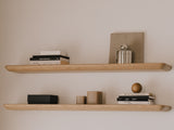 Wooden shelves with decorative items against a plain wall| light oak