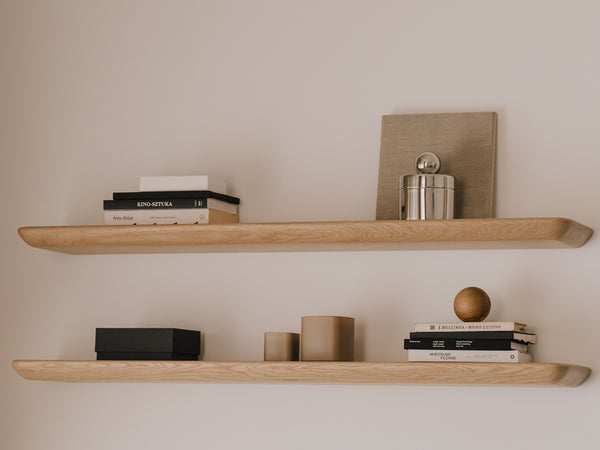 Wooden shelves with decorative items against a plain wall| light oak