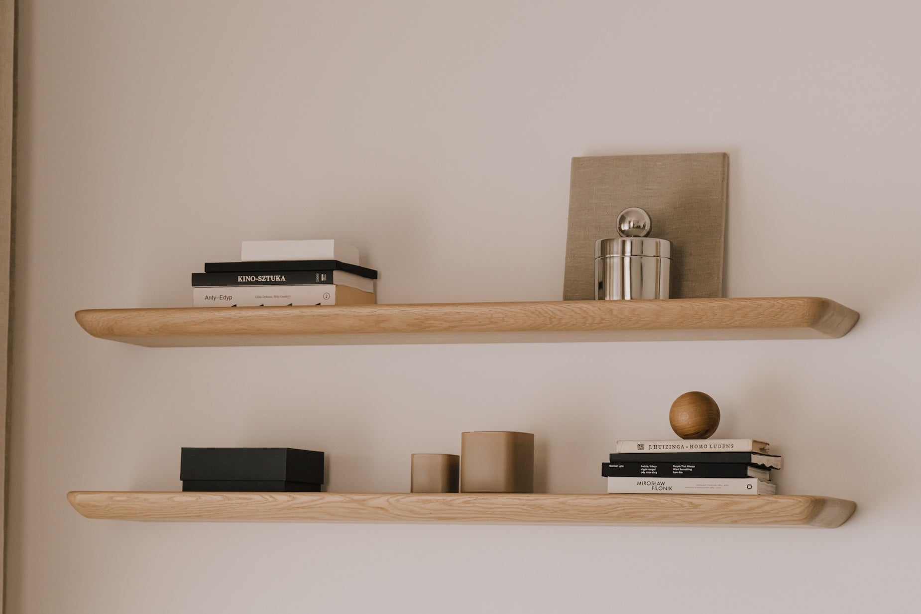 Wooden shelves with decorative items against a plain wall| light oak