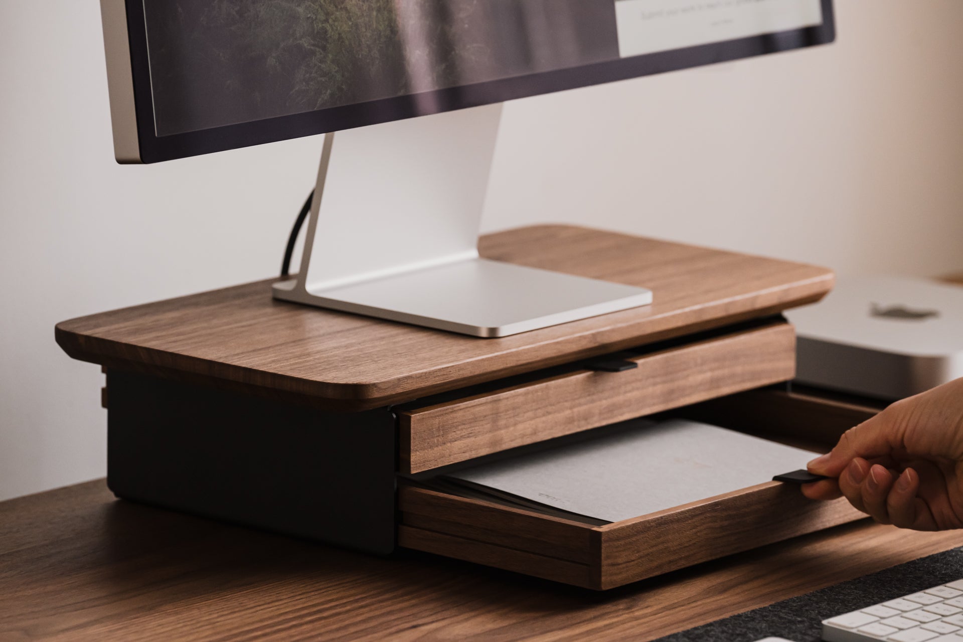 Monitor on a wooden stand with storage drawers, shown from a low angle