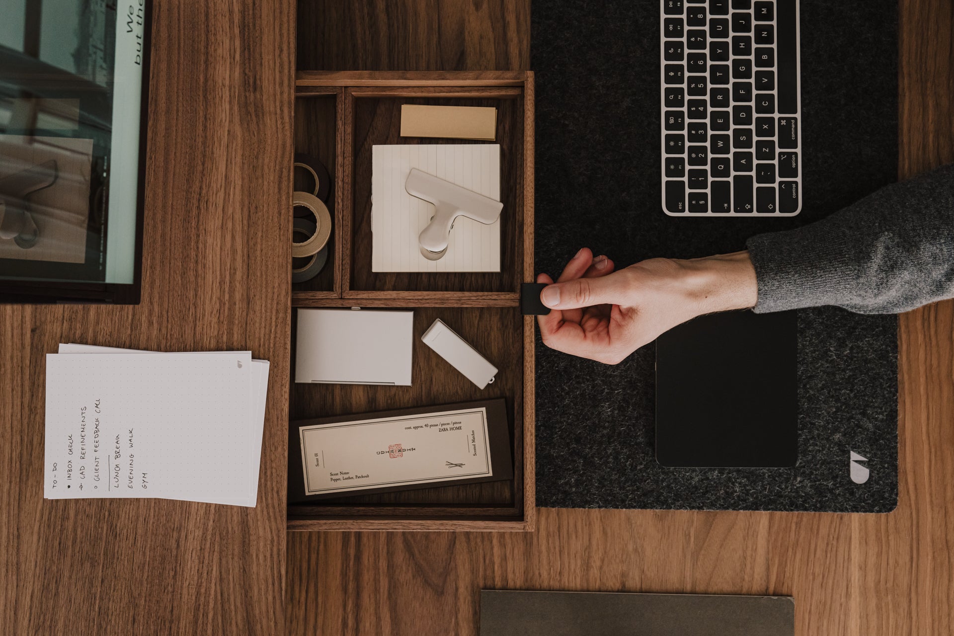 Person organizing items in a wooden desk organizer with a laptop and papers on a wooden desk. | walnut, 