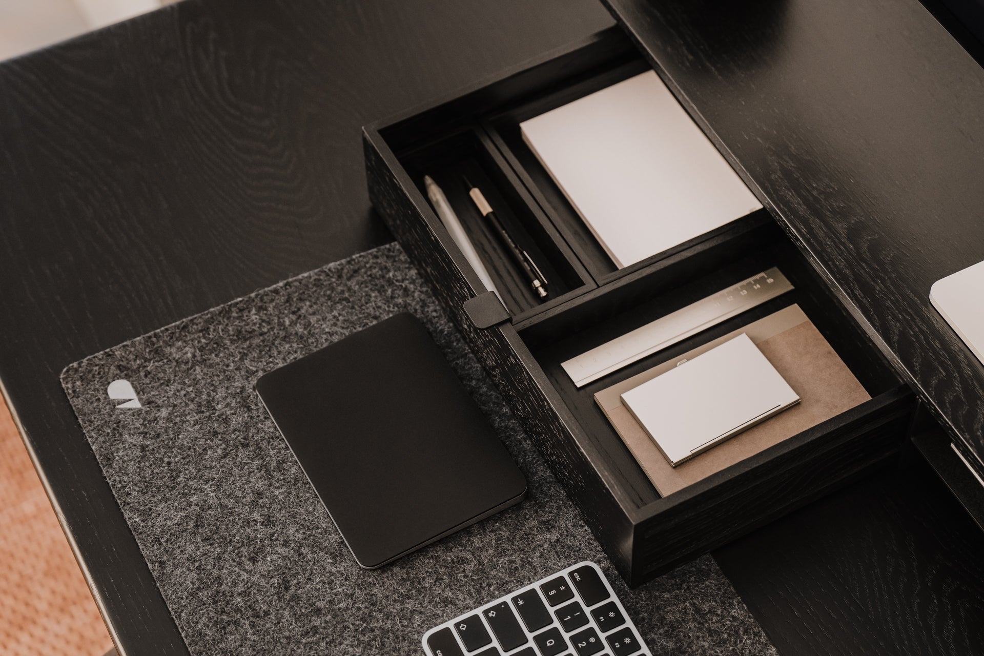 Desk setup with a black stationery set, mouse pad, and keyboard.  | black, 