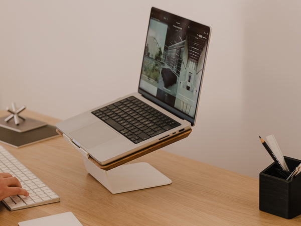 Laptop on a stand with a person using a keyboard on a wooden desk Oakywood Laptop Riser | oak,