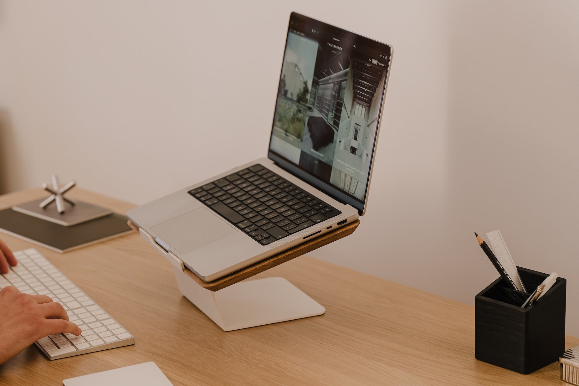 Laptop on a stand with a person using a keyboard on a wooden desk Oakywood Laptop Riser | oak,