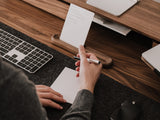 Person taking notes at a desk with oakywood to-do desk kit | walnut