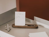 White card with text on a wooden tray on a desk | walnut