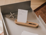 to-do list holder with a pen, small object, and paper on a wooden surface | oak