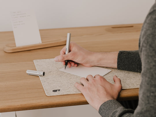 Person writing analog to-do list on oakywood to-do desk cards|-