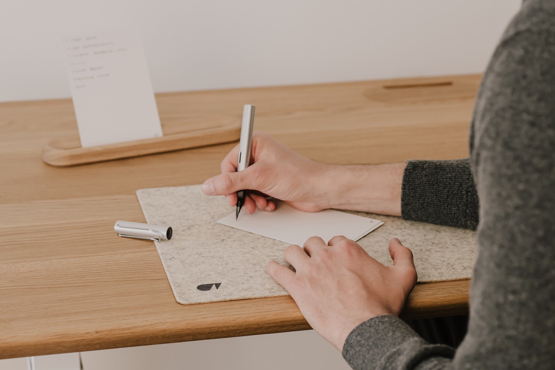 Person writing analog to-do list on oakywood to-do desk cards|-