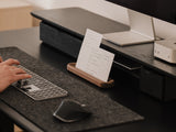 Person using a computer keyboard at a desk with a monitor and small stand holding a to-do list | walnut