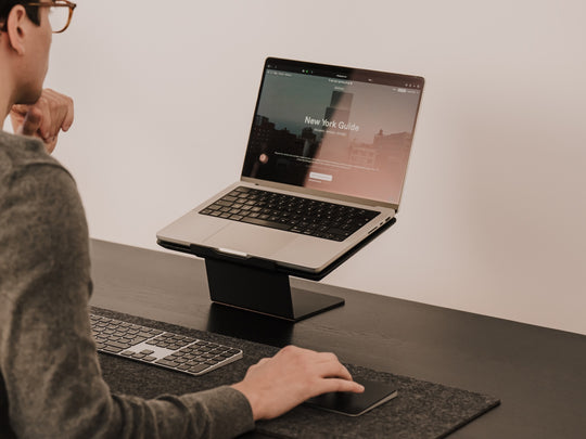 Person using a laptop on a stand at a desk with a minimal background Oakywood Laptop Riser | black,
