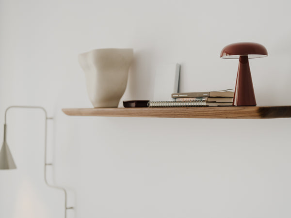 Wide shot of home office with computer desk, shelves, and person working