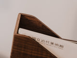 Wooden magazine holder with a piece of paper inside, featuring text | walnut