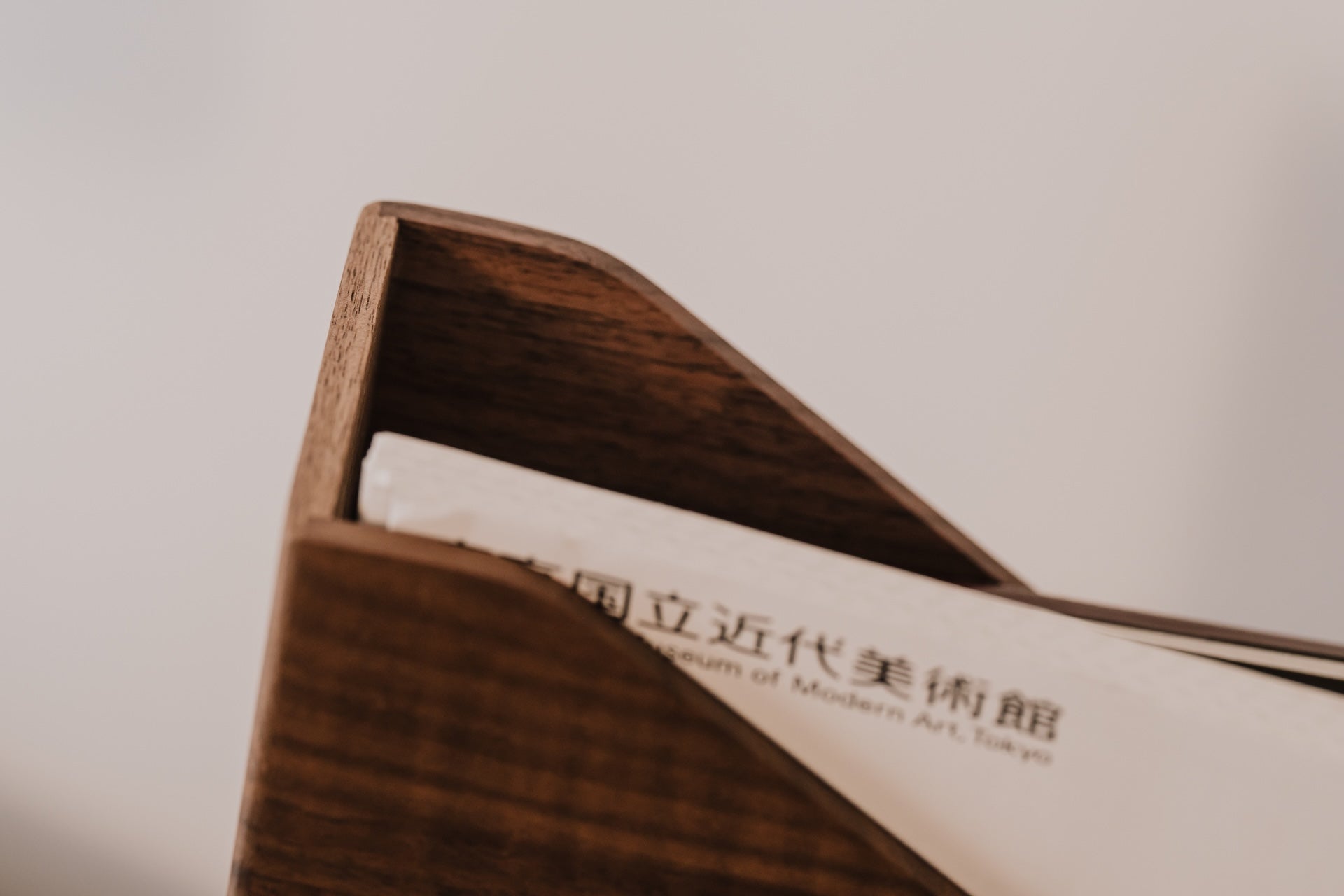 Wooden magazine holder with a piece of paper inside, featuring text | walnut