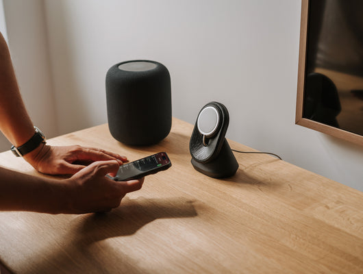 black magsafe iphone mount on a oak wooden desk with spotify music and homepod music center | -