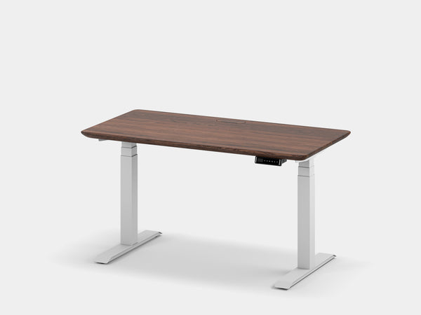 Adjustable-height desk with light gray frame and dark wood top, cable management tray beneath