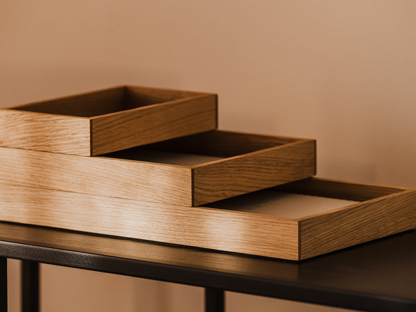 Stackable wooden desk organizer tray on a dark surface against a beige wall | oak, 