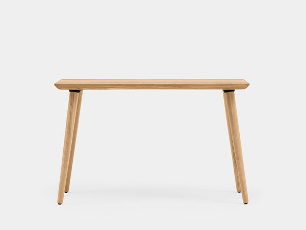 Office desk with light wood surface, rounded corner, and leg close-up.